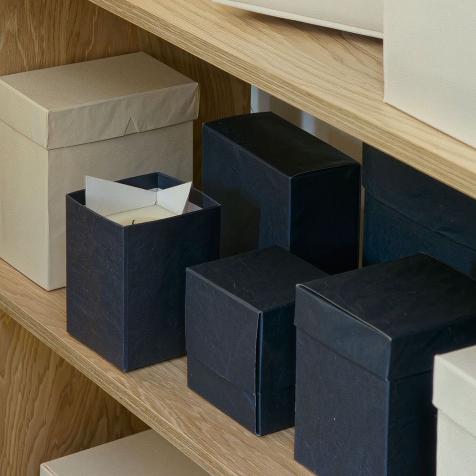 Navy and ivory rigid boxes on a wooden shelf